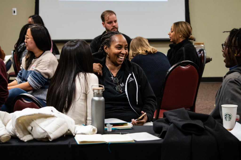 Residents and fellows laugh as they discuss their experiences from their day in small groups. 